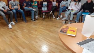 Alunos sentados mostrando livros
